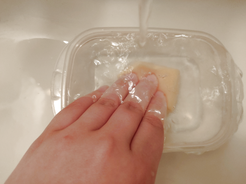 パフを指で押し洗いしている